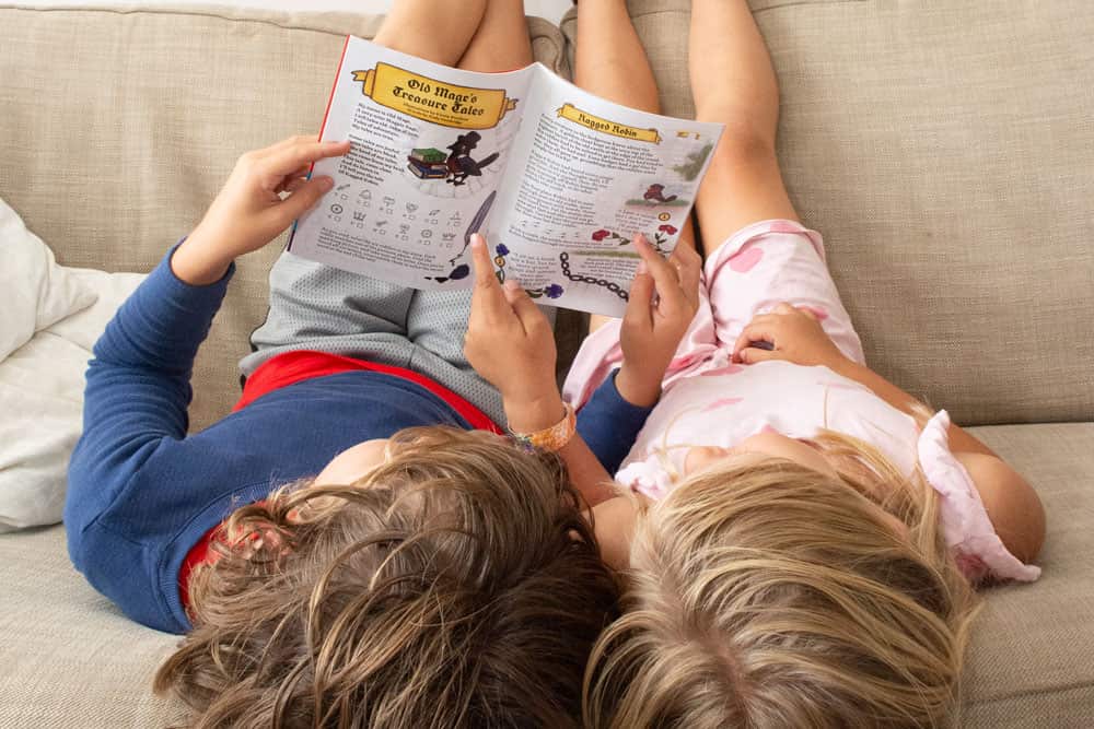 An image of a boy and girl on a sofa reading an issue of The Beyond Comic together